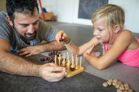 Ein Mann und ein Mädchen beim Brettspiel Kinderphysiotherapie in Mönchengladbach